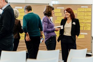 Reger Austausch zweiter Teilnehmerinnen vor einer der Pinnwände, auf der im Laufe des Vormittags Karteikarten geclustert wurden.