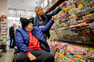 Ein älteres Paar stöbert im Zeitschriftenregal im Supermarkt 