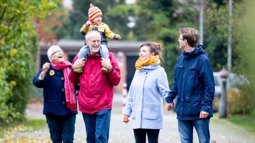 Titelseite der Broschüre der Nationalen Demenzstrategie. Das Titelbild zeigt ein junges Elternpaar und Großelternpaar beim gemeinsamen Spaziergang. Auf den Schultern des Großvaters sitzt ein lachendes Kleinkind.
