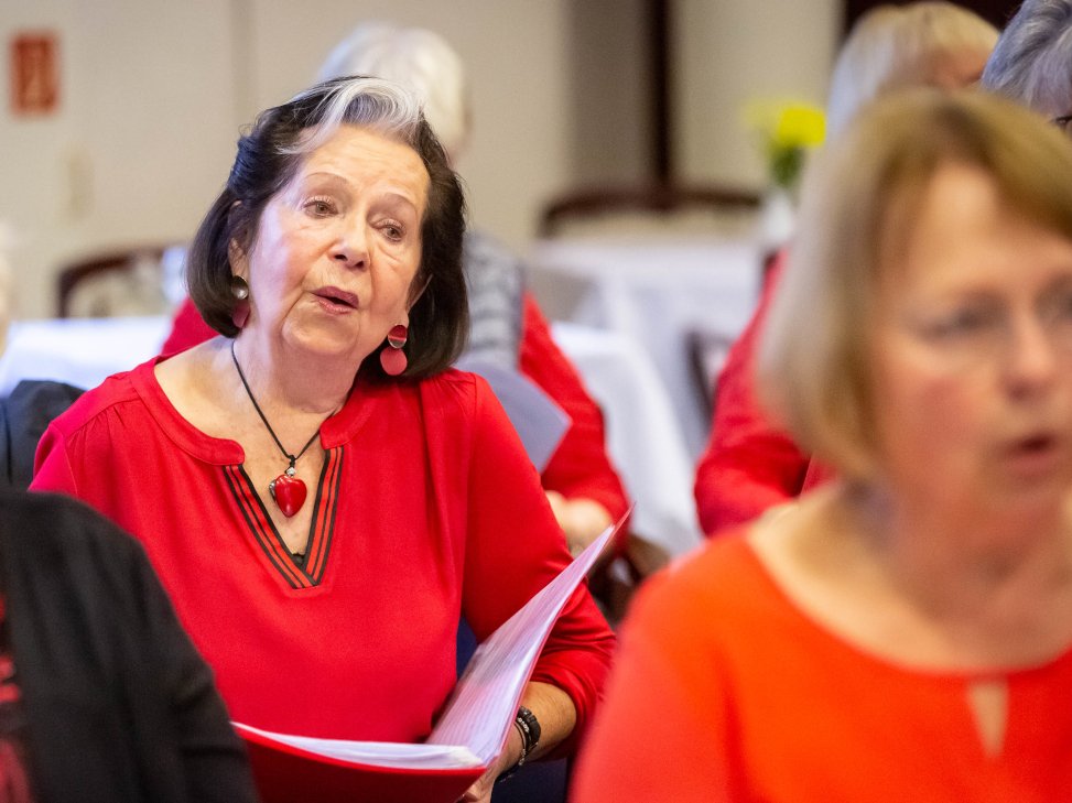 Eine Seniorin singt im Chor