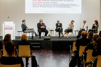 Podium mit Teilnehmenden der Diskussion "Caring Communities – Lebenswerte Orte für Menschen mit Demenz" Das Gespräch führt Okka Gundel, es diskutieren (v.l.n.r.): Stephan Albani (MdB CDU/CSU), Prof. Thomas Klie (Rechtswissenschaftler, Experte Caring Communities), Nadine-Michèle Szepan (AOK Bundesverband), Dr. Irene Vorholz (Deutscher Landkreistag) und Ute Hauser (Alzheimer Gesellschaft Baden-Württemberg)