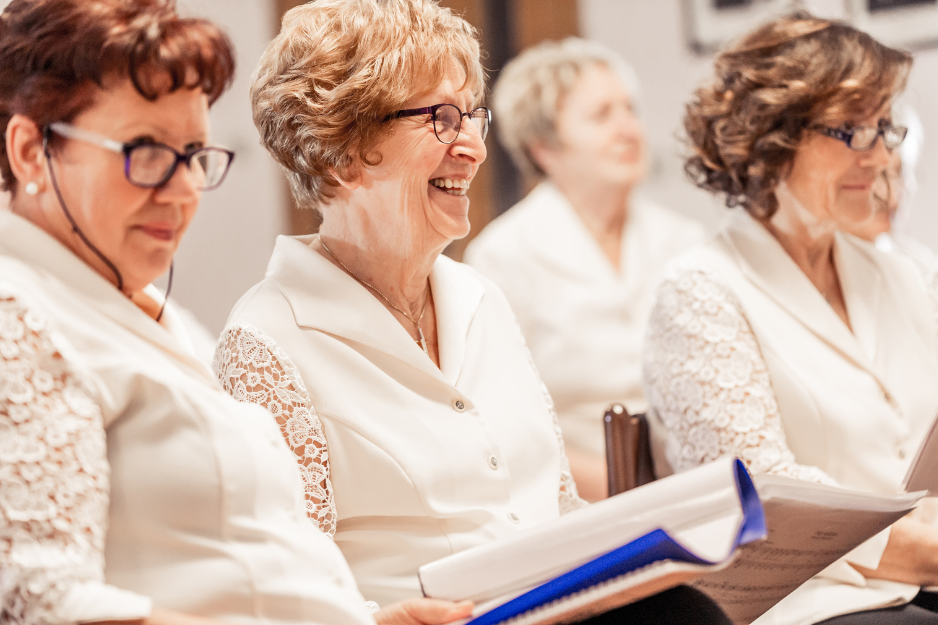 4 ältere Frauen haben Spaß beim gemeinsamen Singen.