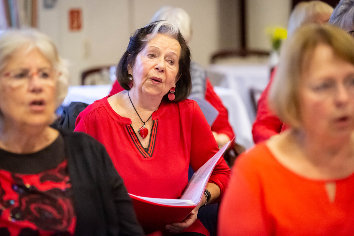 Eine Seniorin singt im Chor