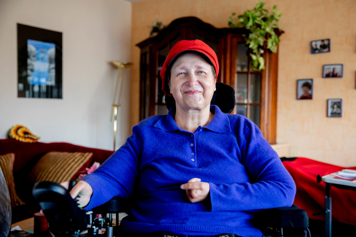Portrait einer lächelnden Seniorin im Rollstuhl 